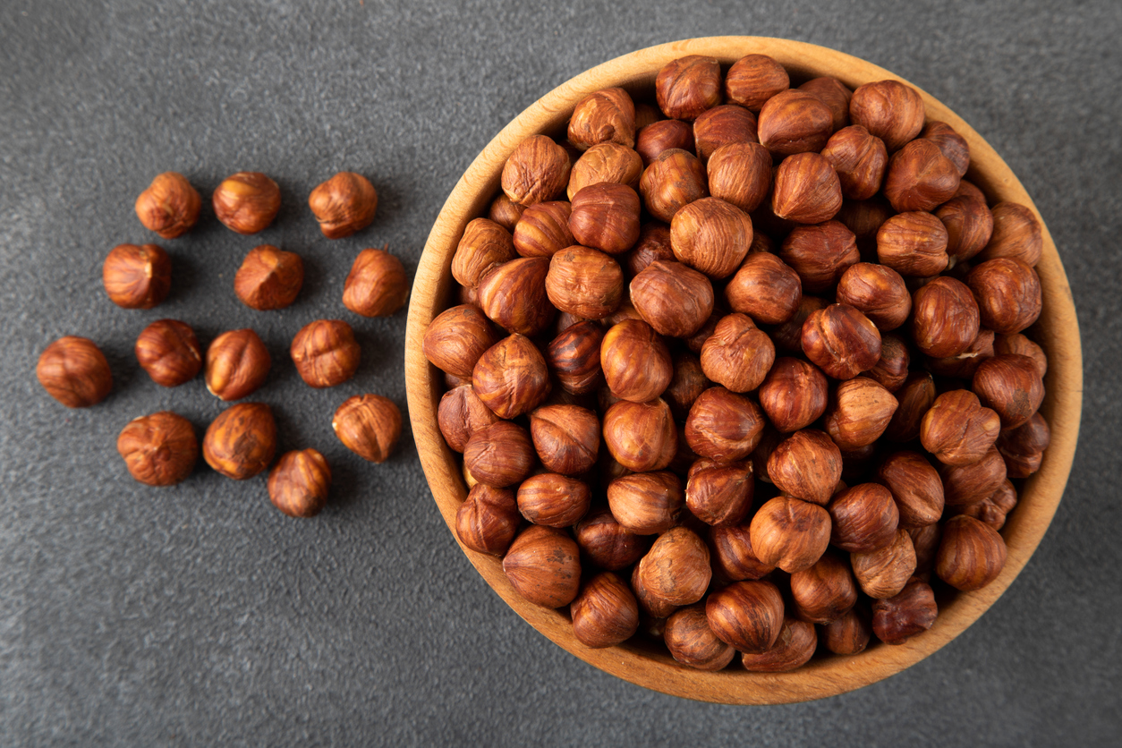 Organic whole hazelnuts in a wooden bowl